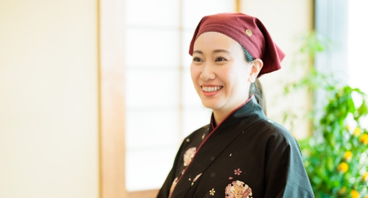 微笑む女性が黒と赤のドレスを着ています。