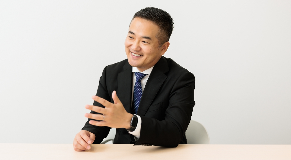 テーブルに座るスーツ姿の男性。