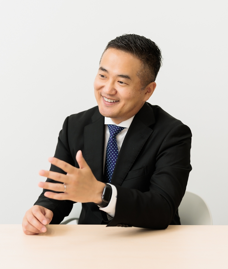 テーブルに座るスーツ姿の男性。