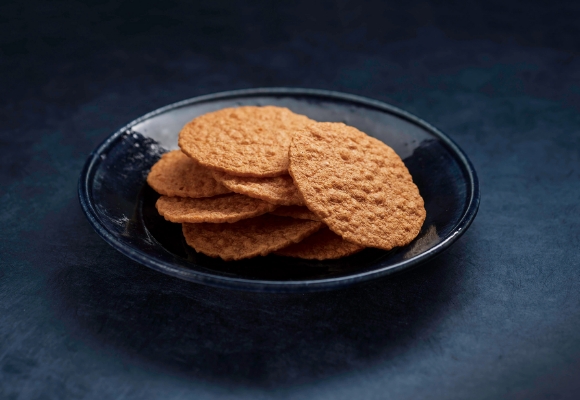 ダークな背景にあるボウルに盛られたクッキー。