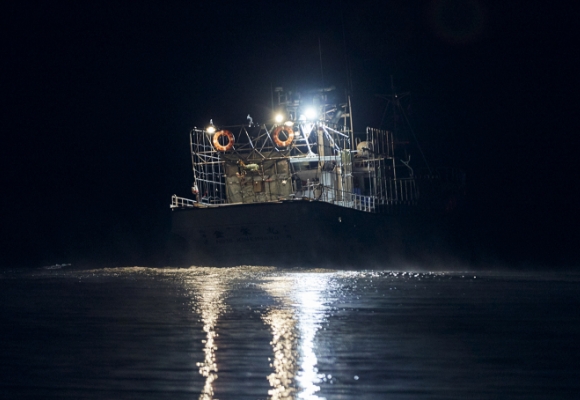 夜の海に停泊する漁船が静かに浮かんでいます。