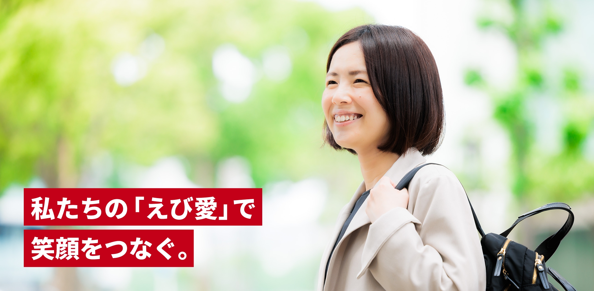 黒いバッグを持ち、微笑む女性の写真。