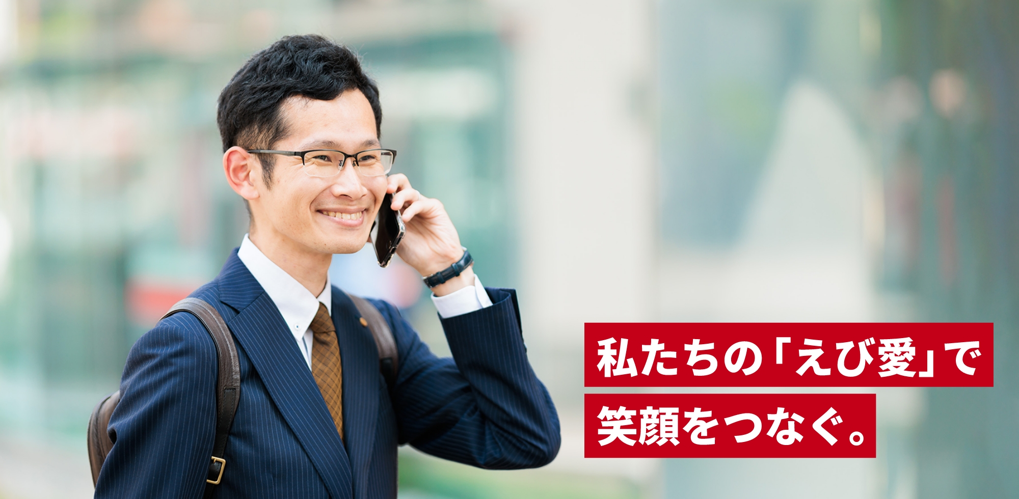 スーツ姿の男性が携帯電話で会話しているシーン。 