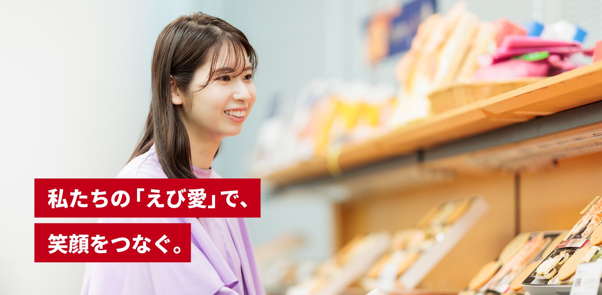 食品が並ぶ棚の前にいる女性。