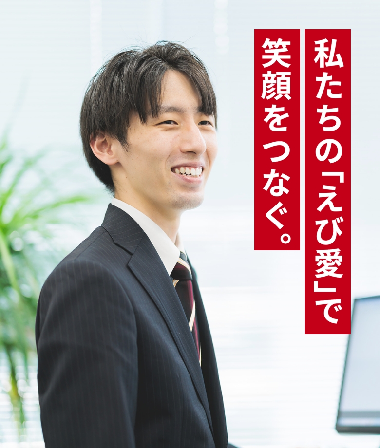 笑顔の男性がスーツを着て、ノートパソコンを手に持っています。