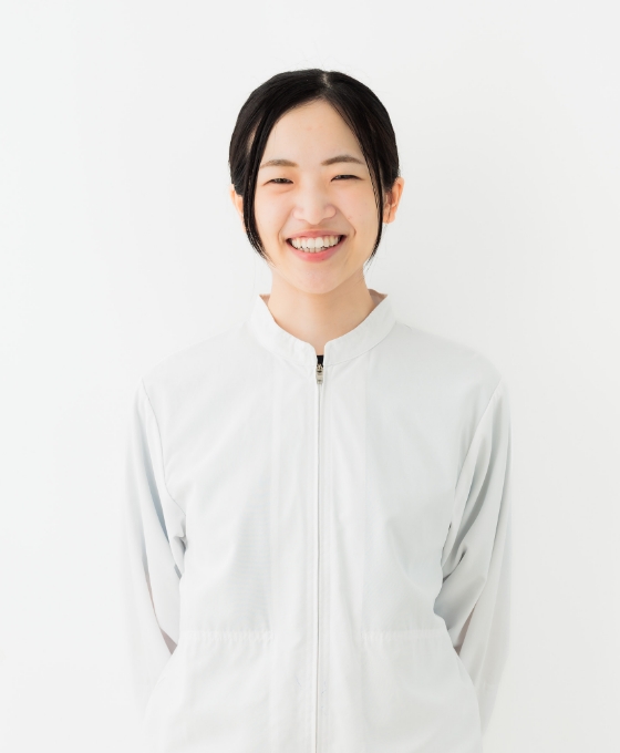 微笑む女性が白いジャケットを着ている様子を捉えた画像です。