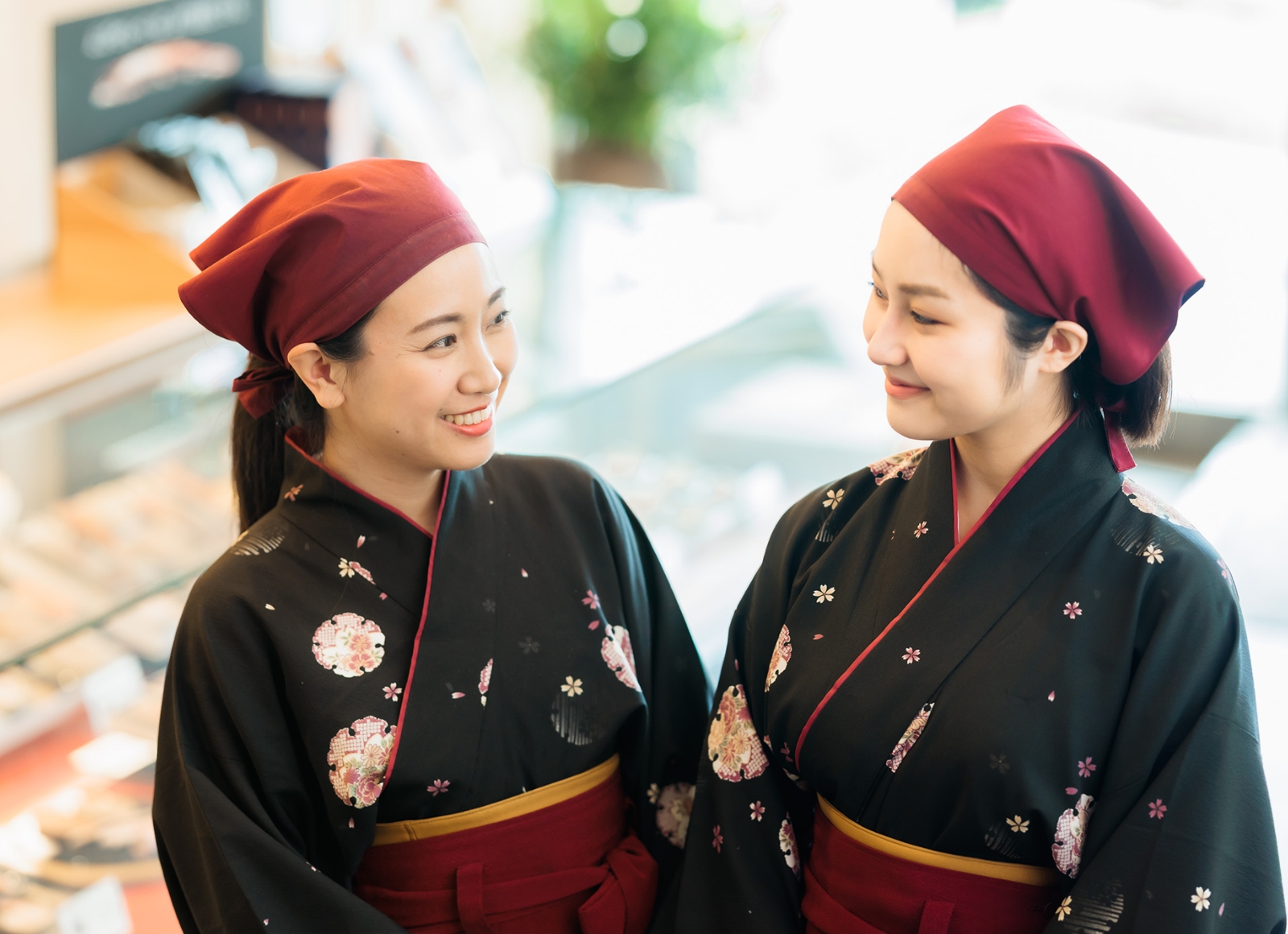 笑顔の二人の女性が伝統的な衣装を着ている様子を捉えた画像です。