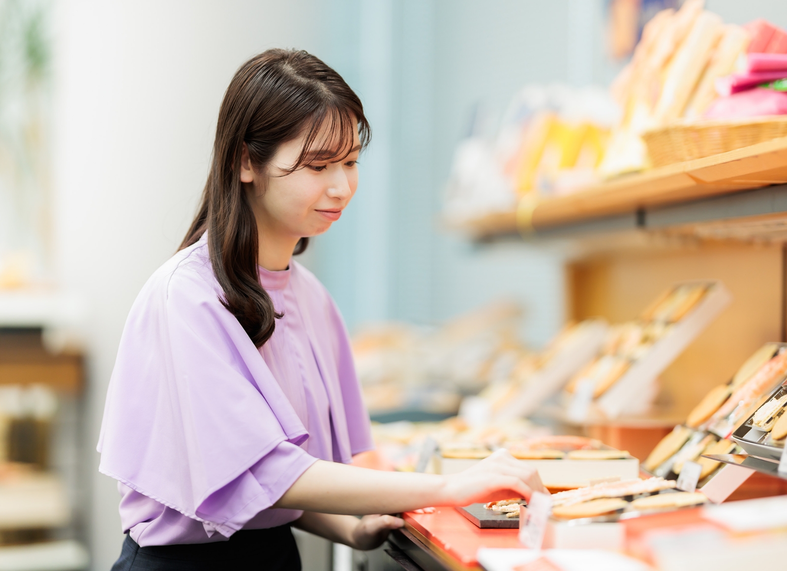 食品を選んでいるアジア系女性がスーパーでの様子。