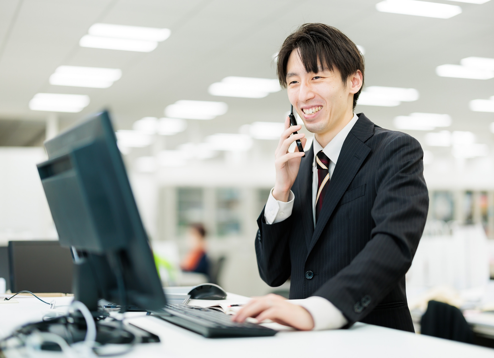 スーツ姿の男性が携帯電話を使って会話している。