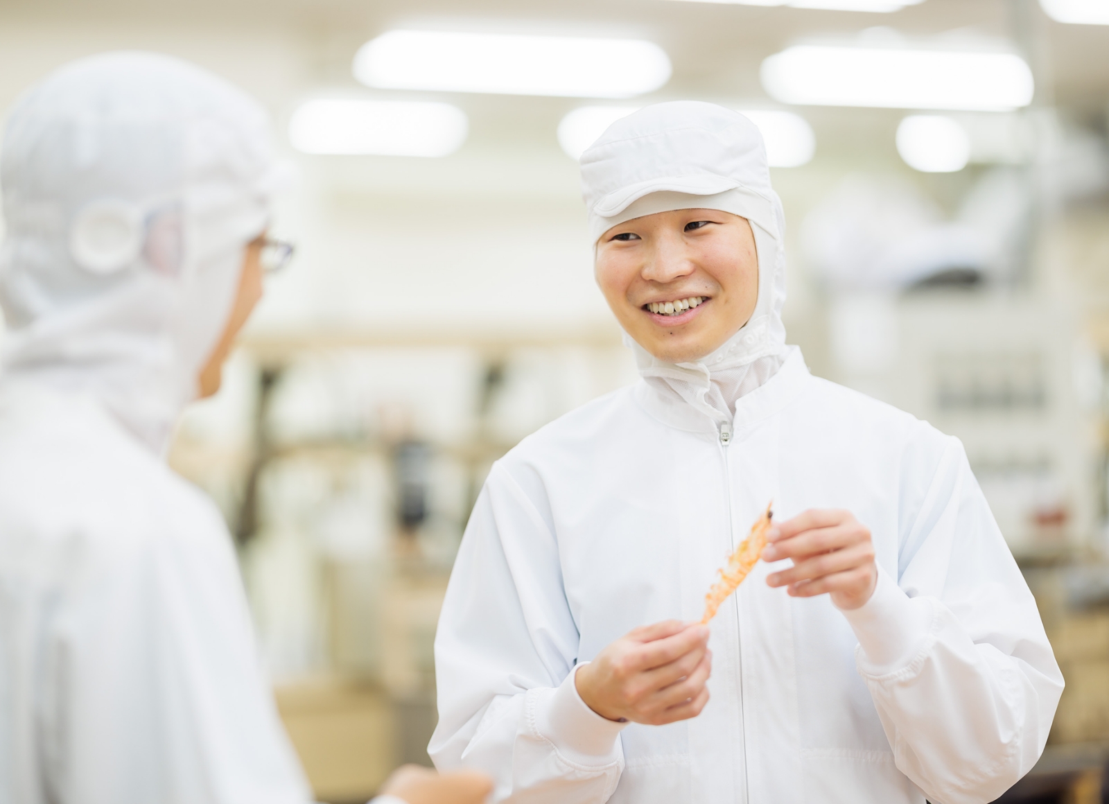 白い衣服を着た二人が微笑みながら並んでいる様子を示しています。