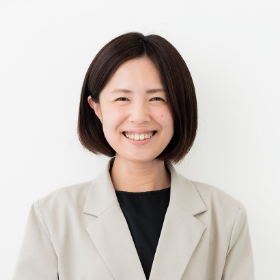 笑顔の女性がスーツと黒いシャツを着ています。