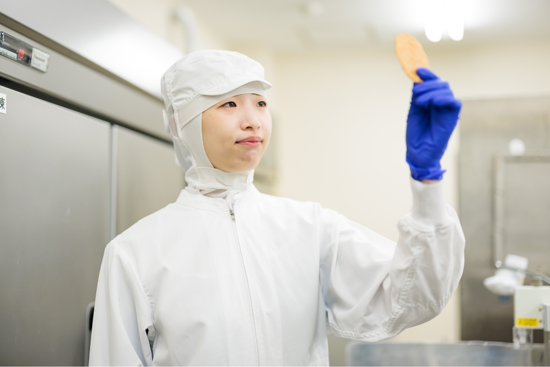 白い lab コートを着た女性が食べ物を持っている画像です。
