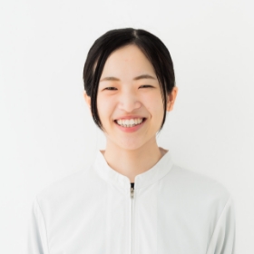 笑顔の女性が白いシャツを着ている様子を捉えた画像です。